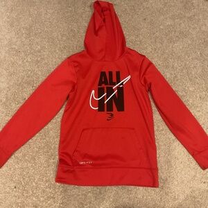 Vibrant red Nike hoodie with 'ALL IN' graphic. Features Dri-FIT technology.